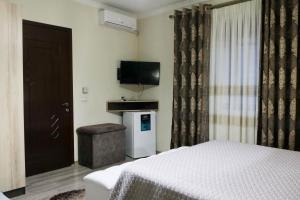 Dormitorio con cama, TV y taburete en Vila Leo Lux en Korçë