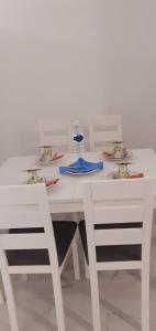 a white table with two chairs and a bottle of water at Ammoudaries appartment in Lakkíon