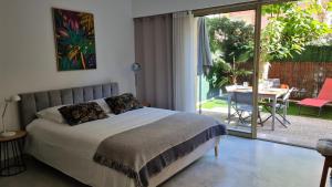 um quarto com uma cama e um pátio com uma mesa em Studio Sun-Beach avec parking et jardin - 500m des plages de Juan Les Pins em Antibes