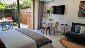 1 dormitorio con 1 cama y sala de estar con mesa en Studio Sun-Beach avec parking et jardin - 500m des plages de Juan Les Pins, en Antibes
