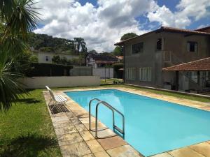 a swimming pool in front of a house at Espaço com piscina em Teresópolis. in Teresópolis