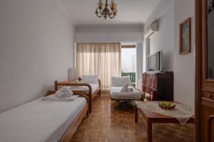 um quarto de hotel com duas camas e uma mesa em ΔΙΠΛΑ ΣΕ ΜΕΤΡΟ , ΚΟΝΤΑ ΣΤΗΝ ΑΚΡΟΠΟΛΗ em Atenas