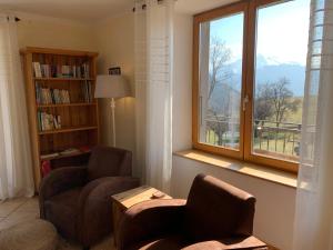 sala de estar con 2 sillas y ventana en Les Chanterelles Montmin, en Plan Motmin