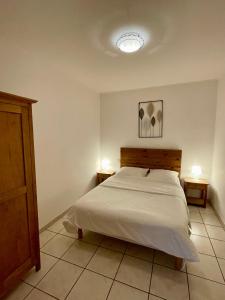 a bedroom with a bed and two nightstands and two lamps at Ô Coeur Des Ocres in Roussillon