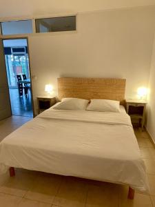 1 dormitorio con 1 cama blanca grande y 2 mesas en Ô Coeur Des Ocres, en Roussillon