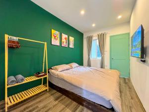 Un dormitorio con una cama y una pared verde. en Home4u, en Hanói 11 fotos más