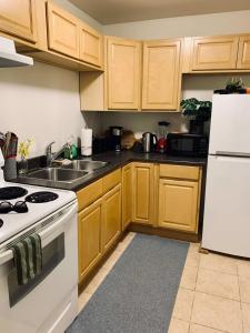 a kitchen with wooden cabinets and a white stove top oven at Pet-Friendly Lovely Studio #2, Balcony in Halifax