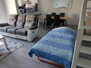 a living room with a bed and a couch at Joli appartement dans quartier calme de Perpignan in Perpignan