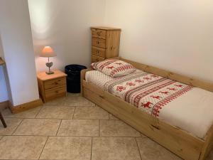Plan MotminにあるLes Chanterelles Montminのベッドルーム1室(ベッド1台、ドレッサー、ランプ付)