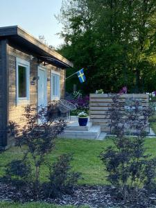 ein kleines Haus mit einer Flagge davor in der Unterkunft Strandnära stuga Torsö, Sölvesborg, Blekinge skärgård in Torsö