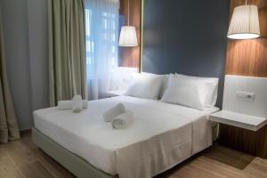 a bedroom with a bed with white sheets and pillows at Apart-Hotel Vasilisa EVN Airport in Pʼarakʼar