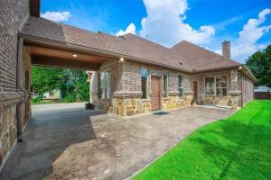 a brick house with a garage and green grass at Grapevine Luxury Home in Grapevine