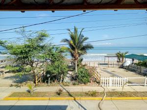 a view of a beach with palm trees and the ocean at Los Pinos condominio piso 2 in Zorritos