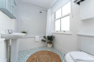a bathroom with a sink and a toilet and a rug at Charming & Homely - 5 mins from Train Station in Brighton & Hove