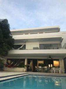 une maison avec une piscine en face d'un bâtiment dans l'établissement El Encanto Beach House, à Santa Marta