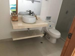 La salle de bains est pourvue d'un lavabo et de toilettes. dans l'établissement El Encanto Beach House, à Santa Marta
