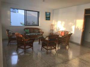 - un salon avec des chaises, une table et une fenêtre dans l'établissement El Encanto Beach House, à Santa Marta