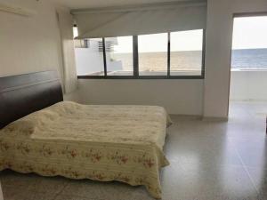 - une chambre avec un lit et une vue sur l'océan dans l'établissement El Encanto Beach House, à Santa Marta