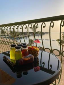 einen Tisch mit drei Gläsern Honig und einem Obstkorb in der Unterkunft فاوتشر فان بيتش in Durrat Al-Arus