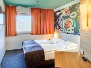 a hotel room with a bed and a window at B&B Hotel Mainz-Hechtsheim in Mainz