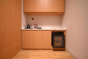 a kitchen with a small refrigerator with drinks in it at Double Nine Hotel in Malino