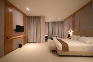 a hotel room with a large bed and a television at Double Nine Hotel in Malino