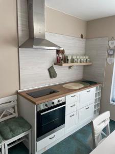 a kitchen with white cabinets and a stove top oven at NiDo Cozy 3BR Apartment Kapana Top Center in Plovdiv