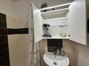 a bathroom with a sink and a white cabinet at Cozy studio apartment in the wider center in Nivy