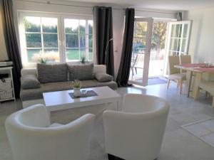 a living room with white chairs and a couch at Villa Vogelsang VO, Schwimmbad, Sauna in Sierksdorf