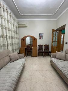 a living room with two couches and a table at Trumpets Apartment in Tirana