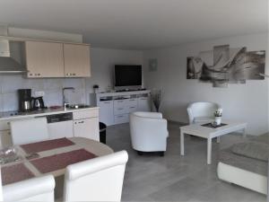 cocina y sala de estar con mesa y sofá en Villa Vogelsang VO3, Schwimmbad, Sauna, en Sierksdorf