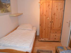 Kleines Zimmer mit einem Bett und einem Holzschrank. in der Unterkunft Holiday home Wehlauer in Rerik