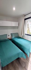 a bedroom with two beds and a window at Mobil-home 6 personnes - Camping SIBLU Bonne Anse Plage in Les Mathes