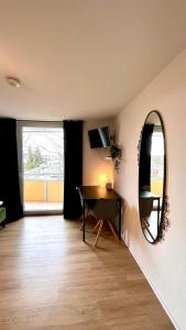 een woonkamer met een tafel en een spiegel bij Ferienwohnung Washingtonweg in Hannover
