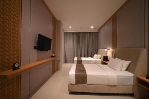 a hotel room with two beds and a television at Double Nine Hotel in Malino