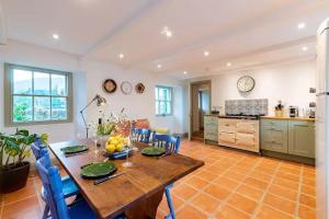 a kitchen with a wooden table and blue chairs at Kenmare Pier Cottage in Kenmare
