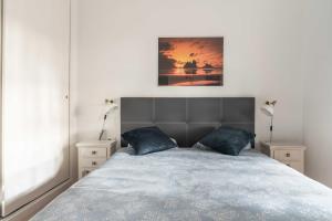 um quarto com uma cama grande e almofadas azuis em Acogedor vistas piscina y Teide em Santa Úrsula