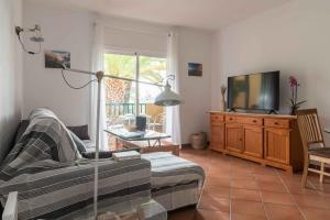 uma sala de estar com um sofá e uma televisão em Acogedor vistas piscina y Teide em Santa Úrsula