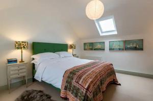 a bedroom with a large bed with a green headboard at Kenmare Pier Cottage in Kenmare