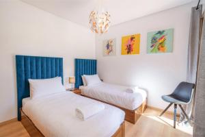 a bedroom with two beds and a chair at Apart Confort Front Pool-Garden in Marrakesh +12 photos