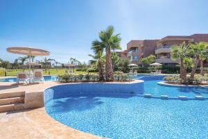 a swimming pool in a resort with palm trees at Apart Confort Front Pool-Garden in Marrakesh