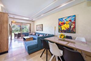 a living room with a blue couch and a table at Apart Confort Front Pool-Garden in Marrakesh