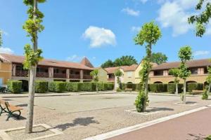 a building with trees in the middle of a parking lot at Studio cabine 5 personnes in Monflanquin