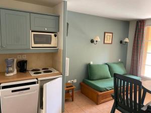 a small kitchen with a couch and a microwave at Studio cabine 5 personnes in Monflanquin