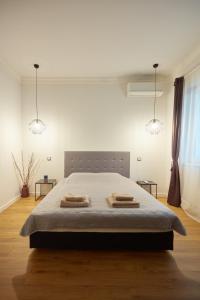 una camera da letto con un letto e due asciugamani di Vitosha Blvd Apt Steps from NDK a Sofia
