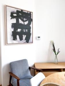 una sala de estar con una silla y una pintura en la pared en New Cozy Apartments In Porte de HAL, en Bruselas