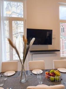 a dining room with a table with a bowl of fruit at New Cozy Apartments In Porte de HAL in Brussels