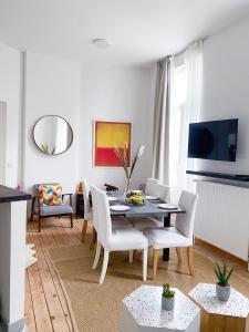 Una sala de estar con una mesa de comedor y sillas. en New Cozy Apartments In Porte de HAL, en Bruselas