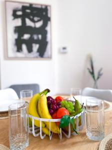 a bowl of fruit on a table with glasses at New Cozy Apartments In Porte de HAL in Brussels