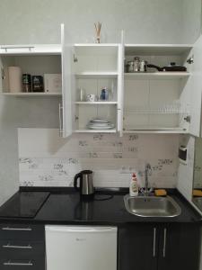 a kitchen with white cabinets and a sink at Cathedral Park Medium Apartment in Chişinău